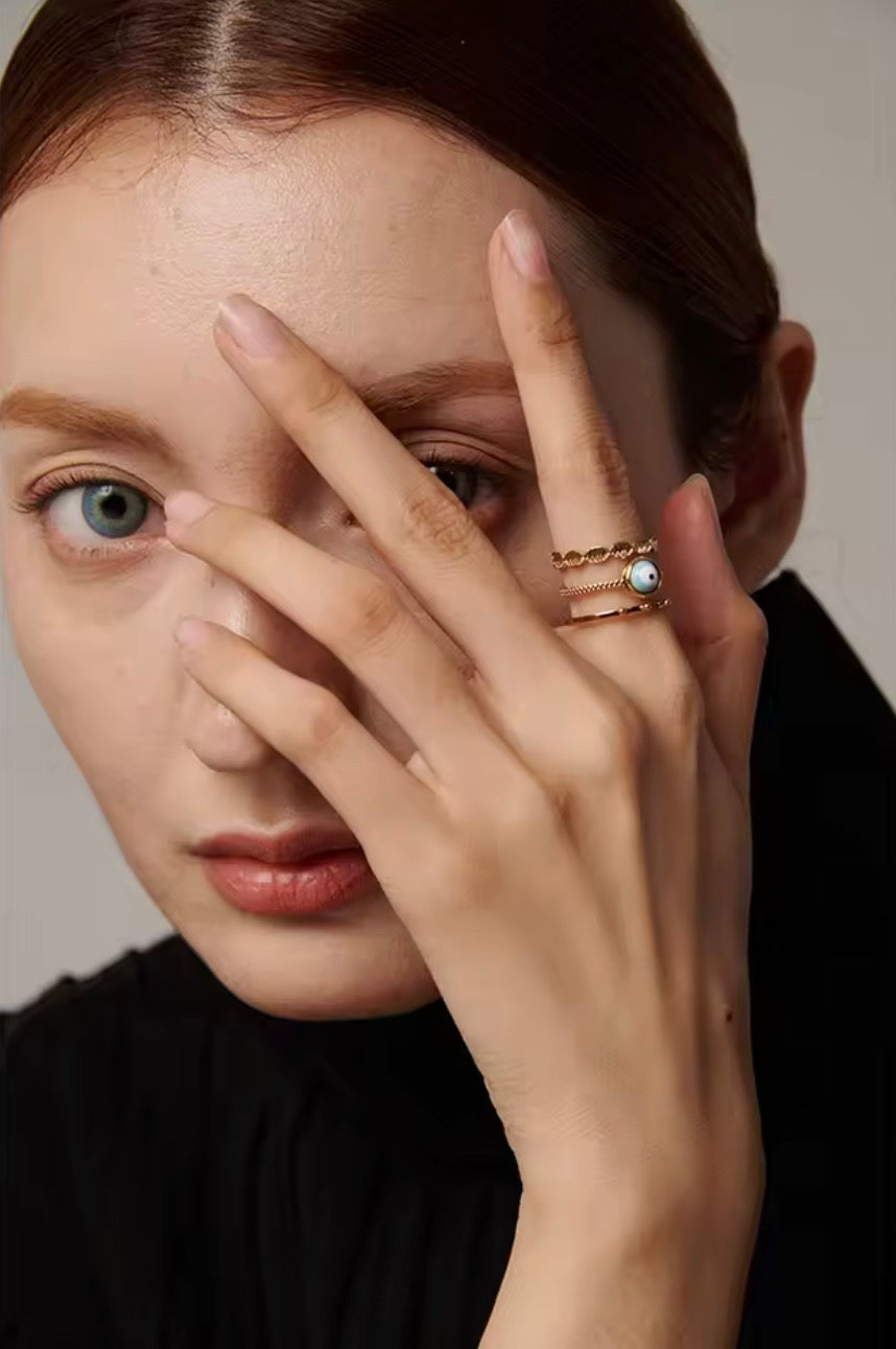 Hand model wearing Evil Eye 3-Layer Ring — 18K gold plated adjustable ring styled with dark editorial look